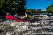 Nova Craft Prospector 15 - Lightweight Canadian Canoe being paddled through whitewater